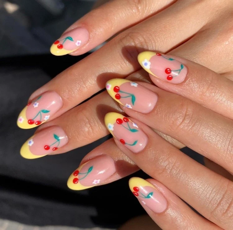 yellow french tip nails with cherries decoration almond shape
