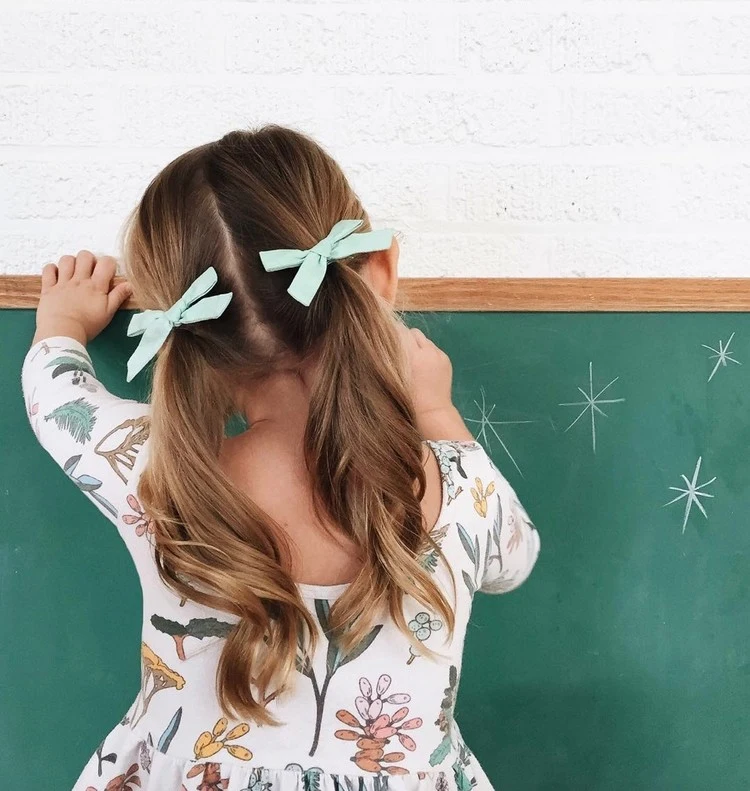 simple low pigtails decorated with pretty bows will make your princesses even cuter