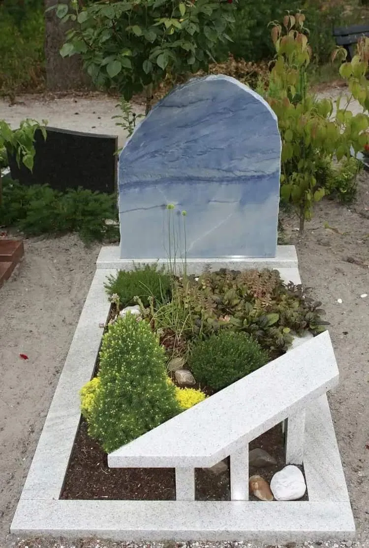 single grave with stone bench and plants decorate grave with stone
