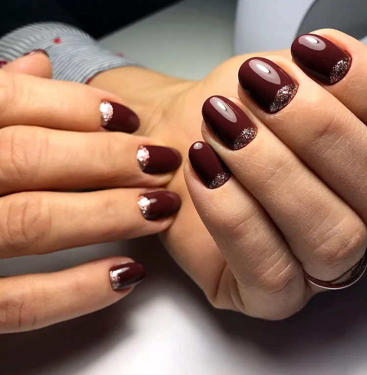 burgundy short oval nails fall 2023 reverse french manicure silver glitter half moon design