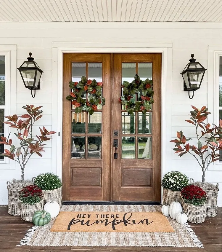fresh magnolia wreath artificial pumpkins potted mums rattan rug fall porch decor design 2023