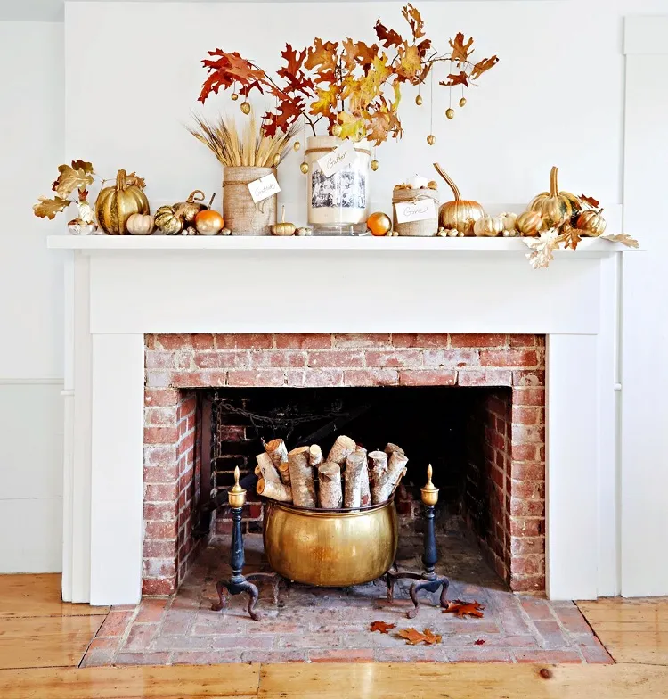 golden fall halloween fireplace mantel decor idea 2023 gold coated pumpkins autumn leaf hanging branches