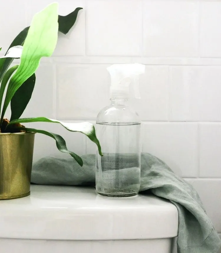 vinegar in a bottle against urine scale under the toilet rim