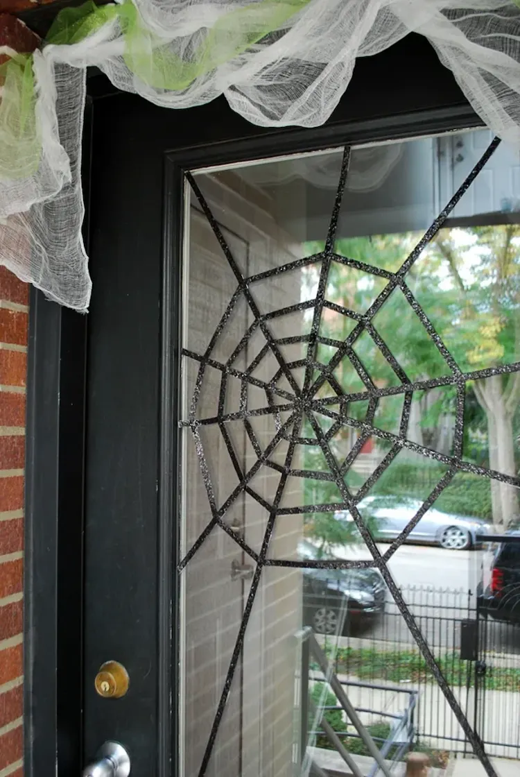 decorate glass front door with spider web for halloween
