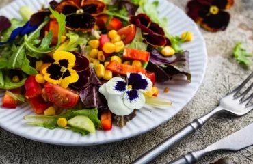 violet flower salad with cucumber corn tomatoes and peppers