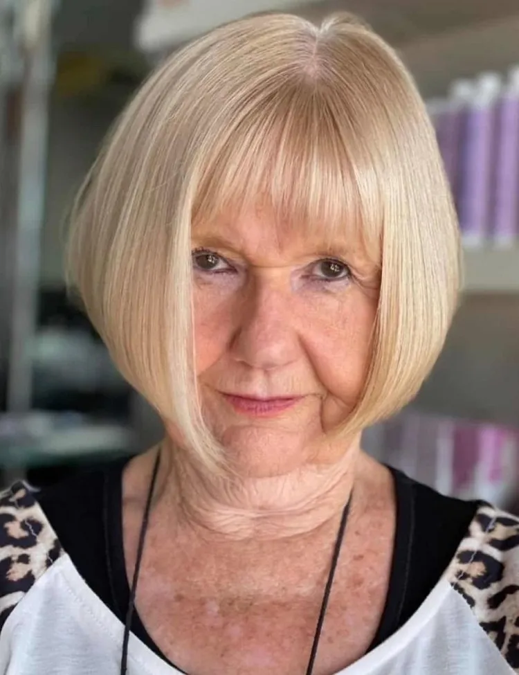 Corte de pelo bob corto invertido asimétrico con flequillo para mujeres mayores de 60 años.