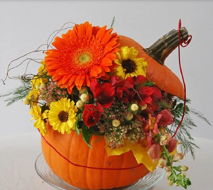 beautiful pumpkin centerpiece with fresh colorful fall flowers and greeenery