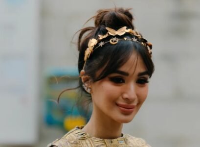 high bun hairstyle curtain bangs gold headband fall winter hair trends 2023