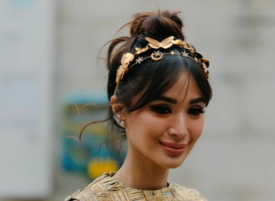 high bun hairstyle curtain bangs gold headband fall winter hair trends 2023