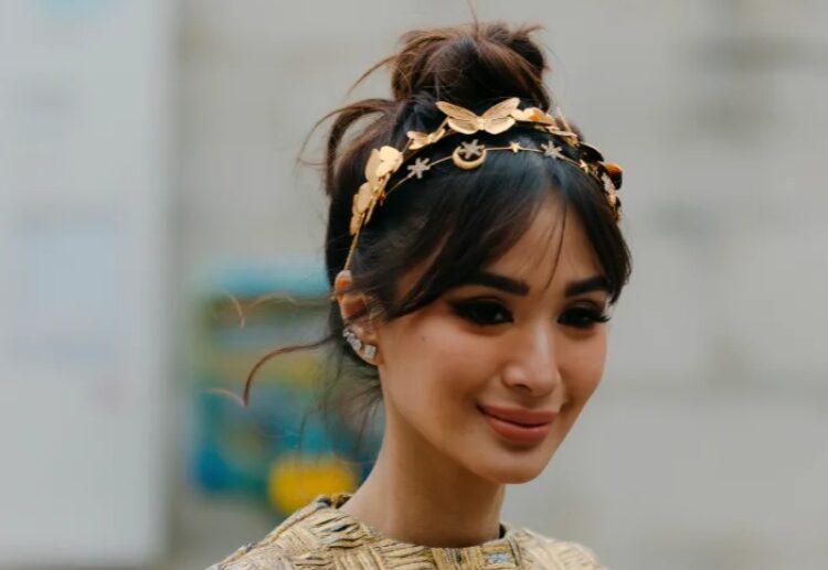 high bun hairstyle curtain bangs gold headband fall winter hair trends 2023