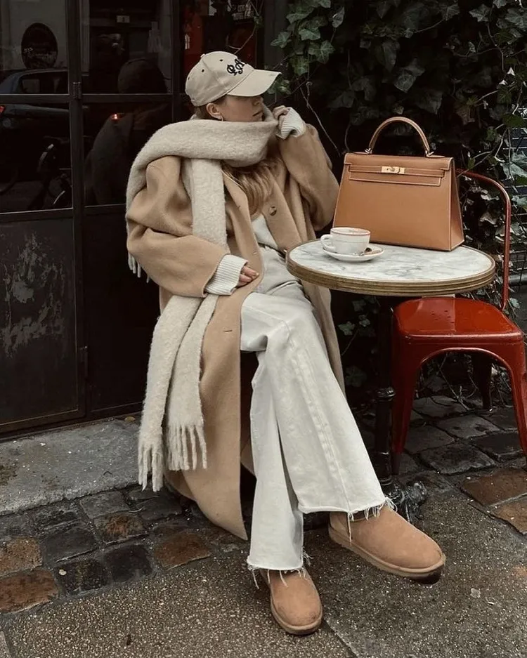 how to style short classic sheepskin ugg boots for work wide leg white jeans oversized long beige coat long taupe scarf baseball hat