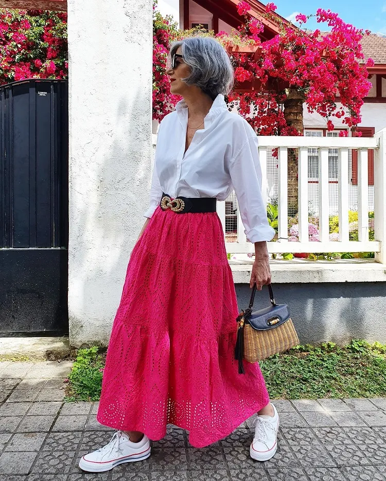 Falda larga de color rosa vibrante, camisa blanca clásica, idea de atuendo elegante y colorido para mujeres mayores de 60 años, otoño de 2023.