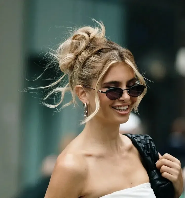 messy high bun face framing tendrils fall winter 2023 hairstyle trends