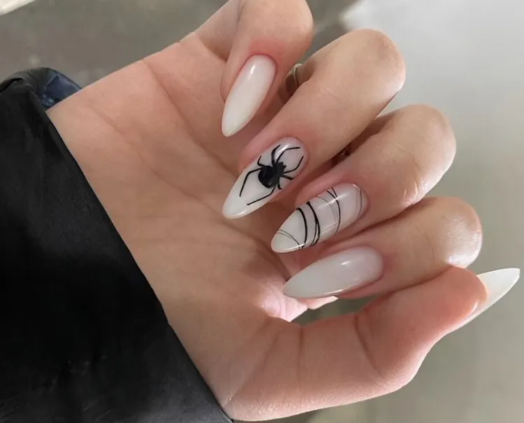 milky white halloween nails with a spider decoration