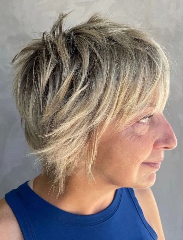 Corte de pelo Shaggy Bob con capas que enmarcan la cara y flequillo para mujeres mayores de 60 años.