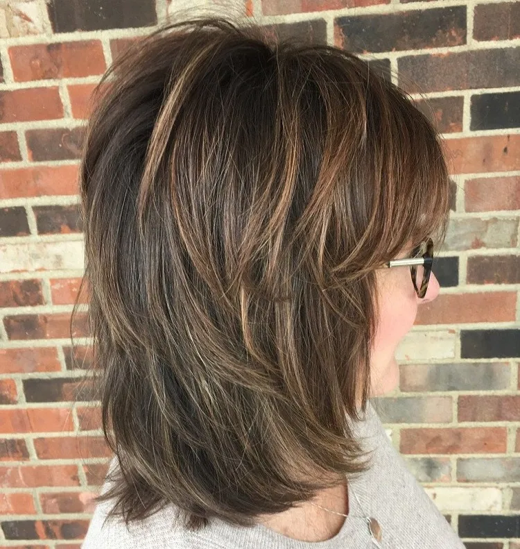 shaggy mid length brunette hairstyle for older women with glasses