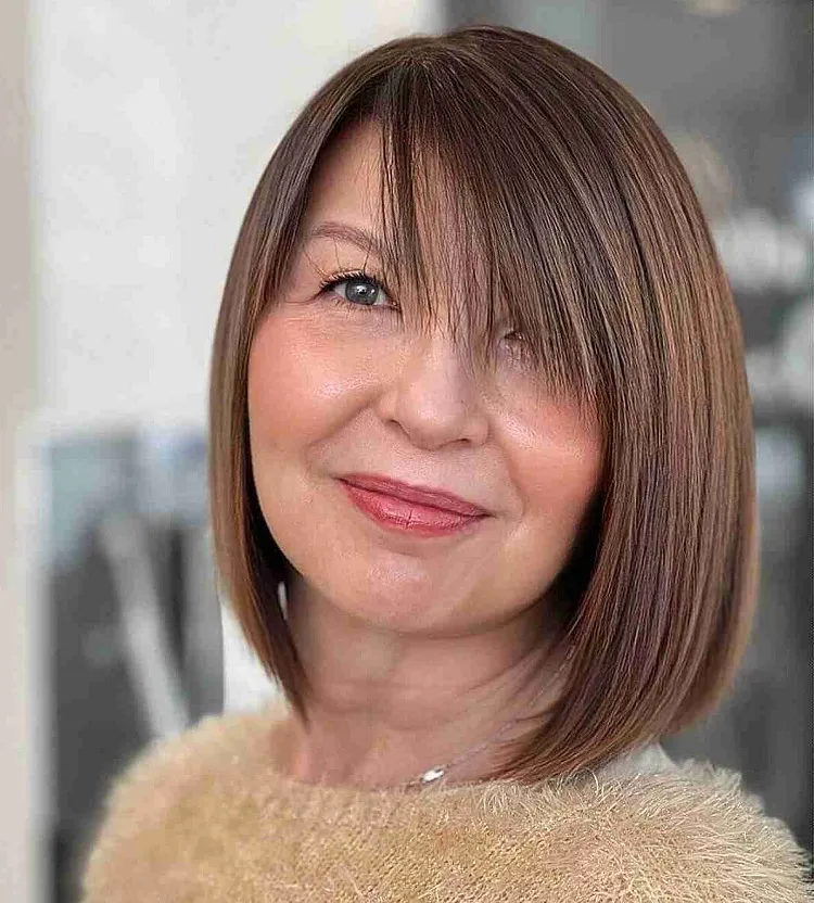 side swept bangs on a chic bob haircut for 50 year olds with fine hair