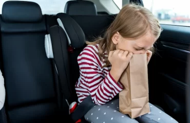 toddler feeling sick in car vomiting in paper bag