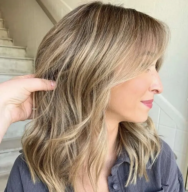 tousled mid length hairstyle over 50 with balayage
