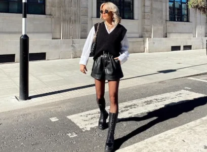 black sweate vest with leather shorts and white shirt style