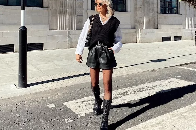 black sweate vest with leather shorts and white shirt style