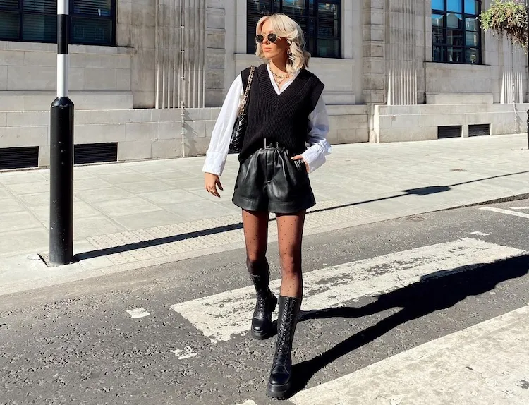 black sweate vest with leather shorts and white shirt style