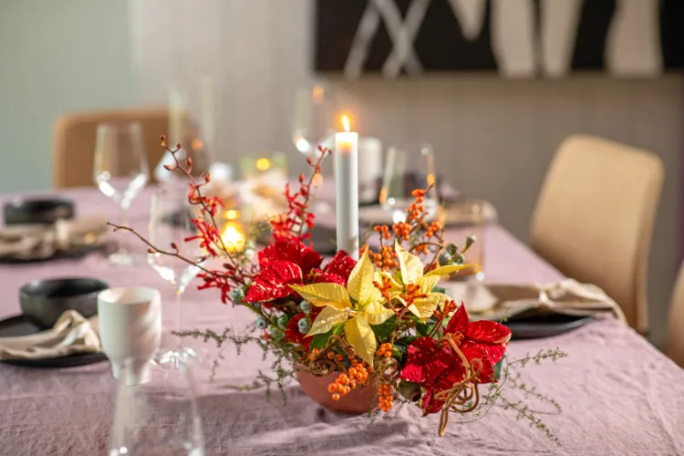 flowers in the center of the table with poinsettia plant for a christmas decoration