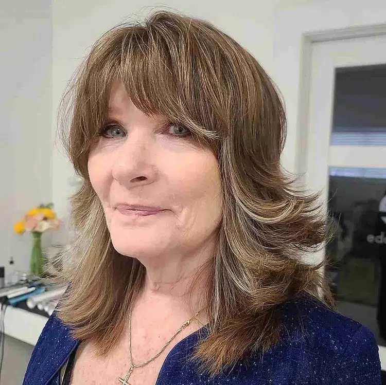 long layered hairstyle curtain bangs 60 year old woman