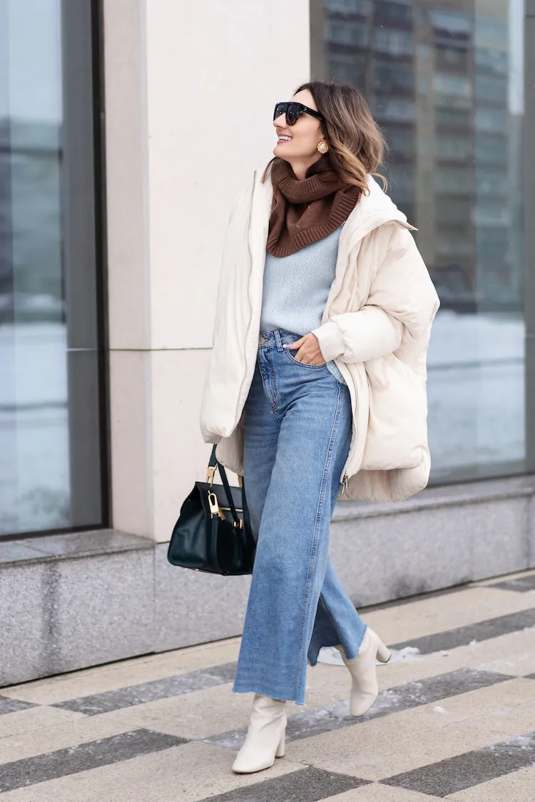 simple casual winter outfit woman puffer coat blue jeans knitwear 2023 2024
