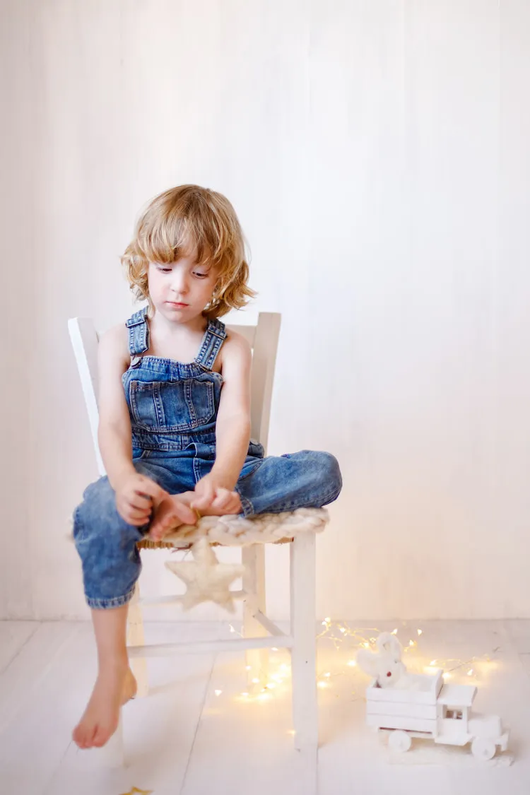 simple minimalist toddler christmas photoshoot outfit idea blue denim dungarees fairy lights