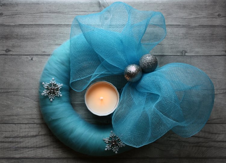 blue,christmas,wreath,sitting,on,wooden,surface,with,a,lighted