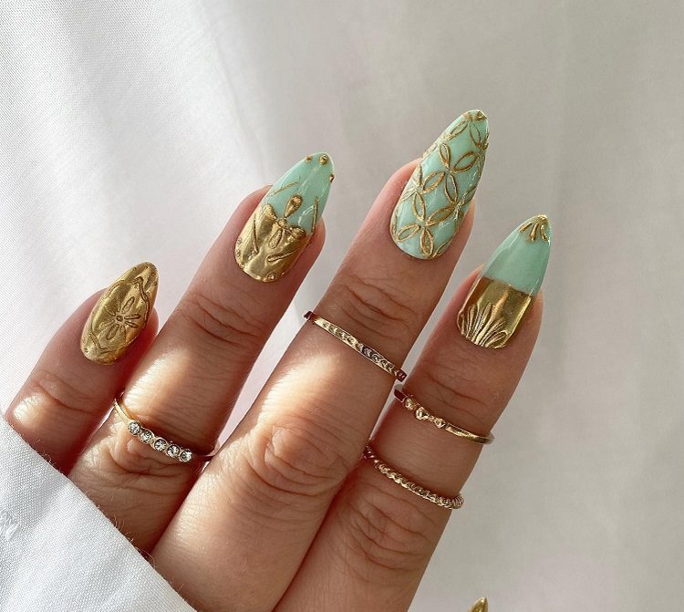 mint green nails gold ornaments festive manicure 2023