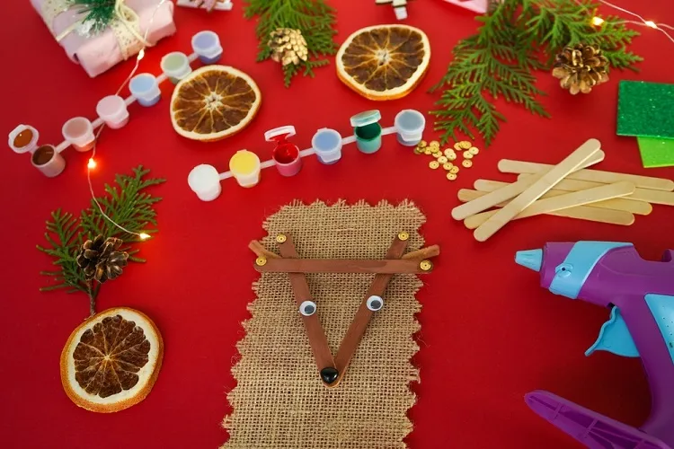 putting googly eyes on diy reindeer christmas tree ornament