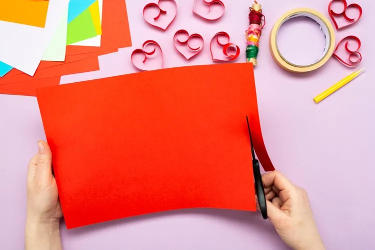 cutting red print paper for diy valentine's day garland