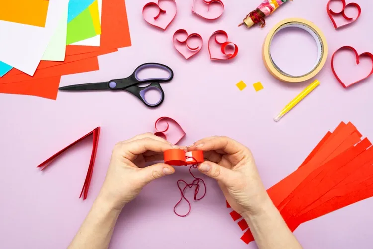 glueing the hearts together with double sided tape for a valentine's day garland