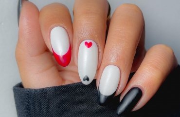 milky white nails with red and black french tips and mini hearts