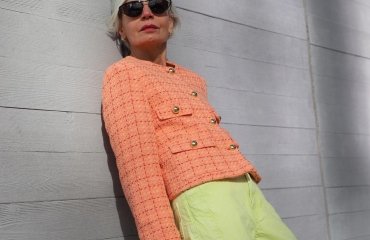 peach fuzz boucle jacket paired with lime green pants and a ontreasting pink bag