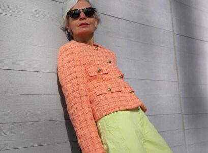 peach fuzz boucle jacket paired with lime green pants and a ontreasting pink bag