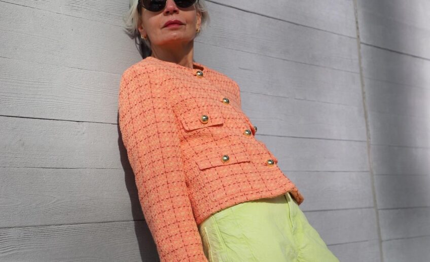peach fuzz boucle jacket paired with lime green pants and a ontreasting pink bag